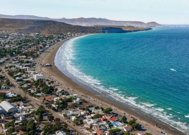 Chubut Eyaleti 'nin kıyı kasabası Rada Tilly' nin panoramik manzarası. Arjantin 'in mavi denizi, kayalıkları ve renkli evleri var.