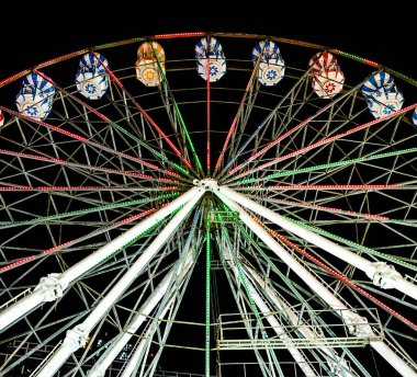 Karanlık gökyüzü arka planındaki tema parkında dönme dolap