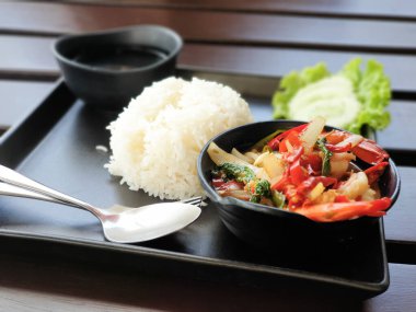 Kızarmış tavuk ve fesleğenli pilav ve sebzeli siyah yemek tepsisi (Tayland 'da popüler yemek))