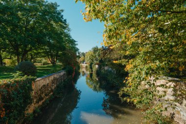 Almanya 'da Bietigheim-Bissingen' in sonbahar renklerine sahip parktaki ahşap bir köprü. Avrupa. Doğada sonbahar manzarası. Ormanda sonbahar renkleri. Nehrin üzerinde ahşap köprüyle sonbahar manzarası