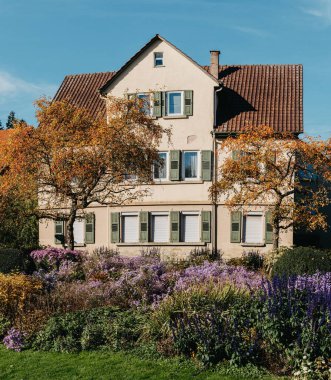 Sonbaharda bahçeli bir ev. Parktaki çiçekler. Bietigheim-Bissingen. Almanya, Avrupa. Autumn Park ve ev, hiç kimse, çalı ve çim