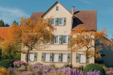 Sonbaharda bahçeli bir ev. Parktaki çiçekler. Bietigheim-Bissingen. Almanya, Avrupa. Autumn Park ve ev, hiç kimse, çalı ve çim