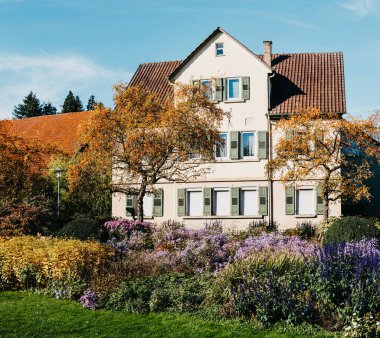 Sonbaharda bahçeli bir ev. Parktaki çiçekler. Bietigheim-Bissingen. Almanya, Avrupa. Autumn Park ve ev, hiç kimse, çalı ve çim