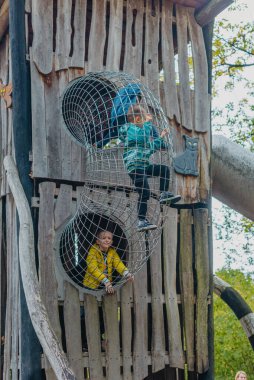 Bir çocuk, sıcak bir yaz gününde parktaki bir çocuk parkına tırmanır. Halk parkındaki çocuk parkı, çocuklar için eğlence ve eğlence, dağcılık eğitimi. Çocuk