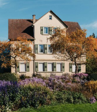 Sonbaharda bahçeli bir ev. Parktaki çiçekler. Bietigheim-Bissingen. Almanya, Avrupa. Autumn Park ve ev, hiç kimse, çalı ve çim