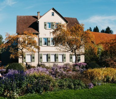 Sonbaharda bahçeli bir ev. Parktaki çiçekler. Bietigheim-Bissingen. Almanya, Avrupa. Autumn Park ve ev, hiç kimse, çalı ve çim