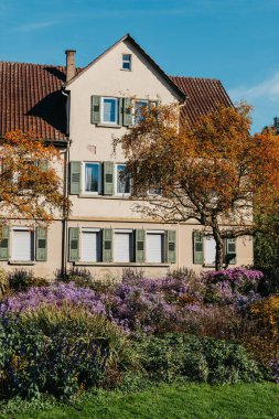 Sonbaharda bahçeli bir ev. Parktaki çiçekler. Bietigheim-Bissingen. Almanya, Avrupa. Autumn Park ve ev, hiç kimse, çalı ve çim