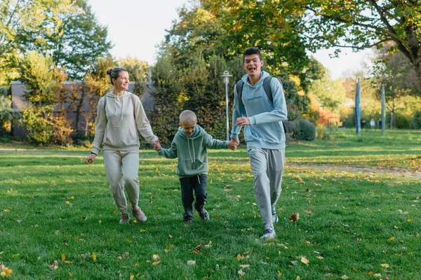 Μια Οικογένεια Μαμά Και Γιοι Διασκεδάζουν Τρέχουν Στο Πάρκο Και — Φωτογραφία Αρχείου