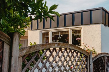 Old white cottage in cozy town. Street view landscape old city, little houses on sunset. Old architecture street front view. Calm old town street. Stone white pink rural cottages and summer gardens.