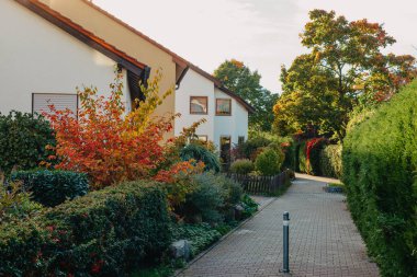 Old white cottage in cozy town. Street view landscape old city, little houses on sunset. Old architecture street front view. Calm old town street. Stone white pink rural cottages and summer gardens.