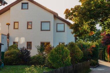 Old white cottage in cozy town. Street view landscape old city, little houses on sunset. Old architecture street front view. Calm old town street. Stone white pink rural cottages and summer gardens.