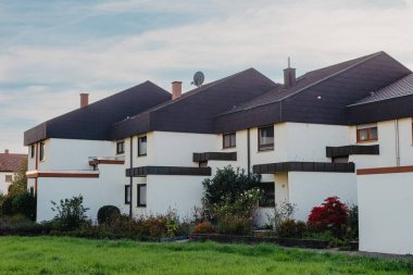 Old white cottage in cozy town. Street view landscape old city, little houses on sunset. Old architecture street front view. Calm old town street. Stone white pink rural cottages and summer gardens.