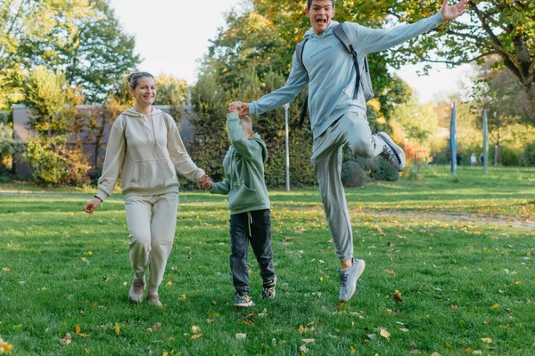 Μια Οικογένεια Μαμά Και Γιοι Διασκεδάζουν Τρέχουν Στο Πάρκο Και — Φωτογραφία Αρχείου