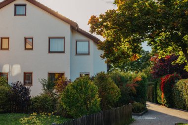Old white cottage in cozy town. Street view landscape old city, little houses on sunset. Old architecture street front view. Calm old town street. Stone white pink rural cottages and summer gardens.