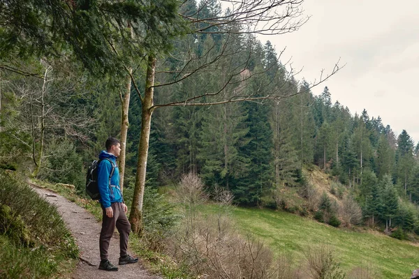 一个背着背包的游客站在山路上遥望远方 旅行和冒险的概念 背包登山的旅行者旅行生活方式的概念山脉 — 图库照片