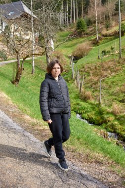 Dağ vadisinde seyahat eden genç ve çekici bir kız yolcunun portresi. Dağın tepesinde poz veren mutlu bir turist. Seyahat ve tatil konsepti. Yürüyüş yolu.