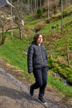 Dağ vadisinde seyahat eden genç ve çekici bir kız yolcunun portresi. Dağın tepesinde poz veren mutlu bir turist. Seyahat ve tatil konsepti. Yürüyüş yolu.