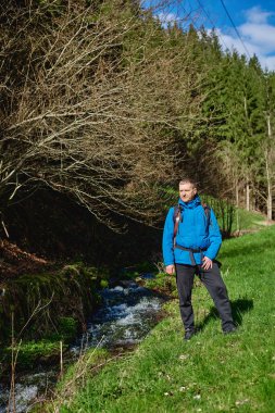 Günbatımı dağlarında ağır sırt çantasıyla yürüyüş yapan bir adam. Seyahat tarzı seyahat, macera dolu yaz tatili kavramı. Açık havada tek başına. Tek başına seyahat eden hippi gezgin.