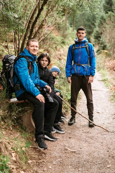 3人の子供が山で休んでいる家族 子供と一緒に旅行やハイキング — ストック写真