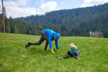 Kardeşler çimenlerde birlikte eğleniyor. Mutlu çocuklar dışarıda eğleniyor. Yaz parkında oynayan çocuklar. Küçük çocuk yeşil çimenlerde yatıyor.