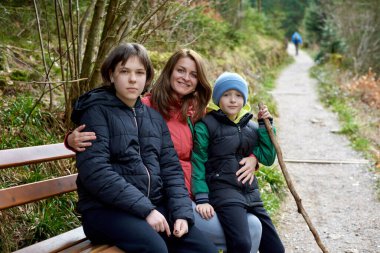 Dağlarda dinlenen üç çocuklu bir aile. Çocuklarla seyahat ve yürüyüş..