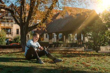 Profesyonel fotoğrafçı güzel bir sonbahar parkının fotoğrafını çekiyor. Profesyonel fotoğrafçı, sonbahar parkında kamerayla oturur.