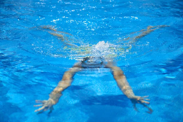 stock image Fit swimmer training in the swimming pool. An overhead view of a man diving into a pool, forming an arrow shape and leaving a trail behind him. Professional male swimmer inside swimming pool. Young