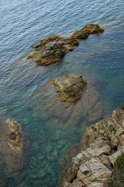 Sudaki kayalar. Üst manzara, denizde koyu mavi deniz suyu dalgası. Yukarıdan aşağıya hava görüntüsü.