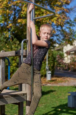 Modern Kaydırak, Halat Ağı Köprüsü, Tırmanış Salıncakları, Tırmanışçılar. Tahta ağaç gövdesinden yapılmış boş ahşap oyun parkı. Parkın bahçesinde renkli bir oyun alanı. Çocuklar