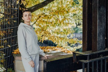 Sonbaharda bir parkta duran zarif bir kadın. Sonbahar sarı yaprakları. Sonbaharda parkta neşeli bir kadının portresi. Sarı yapraklı mutlu kız. Güzel, romantik kız dışarıda eğleniyor.