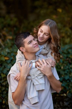 Genç Sevimli Kadın Hugs erkek. Sonbahar açık. Lovers Park'ta yürüyordunuz. Çekici komik çift. Ormandaki lovestory. Erkek ve kadın. Parkta şirin severler. Aile kavramı. Mutlu çift.