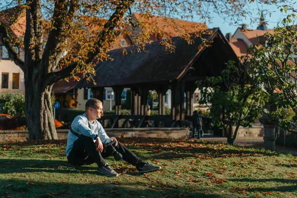 Profesyonel fotoğrafçı güzel bir sonbahar parkının fotoğrafını çekiyor. Profesyonel fotoğrafçı, sonbahar parkında kamerayla oturur.