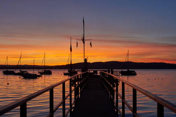 Bodensee Lake Sunrise Panorama 晨光照射在平静的水面上 见证德国波登塞湖畔迷人的黎明 它从船坞中被捕获 拥抱早期的宁静之美 图库照片