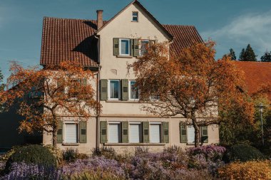 Sonbaharda bahçeli bir ev. Parktaki çiçekler. Bietigheim-Bissingen. Almanya, Avrupa. Autumn Park ve ev, hiç kimse, çalı ve çim