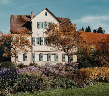 Sonbaharda bahçeli bir ev. Parktaki çiçekler. Bietigheim-Bissingen. Almanya, Avrupa. Autumn Park ve ev, hiç kimse, çalı ve çim