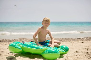 Childhood Beach Bliss: Nine-Year-Old Enjoying Tropical Vacation on Colorful Sea Turtle Float Against Picturesque Coastal Scenery clipart