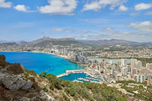 İspanya 'nın çarpıcı Calpe Körfezi' ne bakan kayalıklardan nefes kesici bir manzara berrak suları, kumlu plajları ve parlak mavi gökyüzü altında görkemli kaya oluşumları..