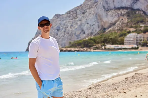 stock image Youthful Beach Adventure: Eighteen-Year-Old Male Model Showcasing Summer Fashion Against Backdrop of Turquoise Ocean Waves