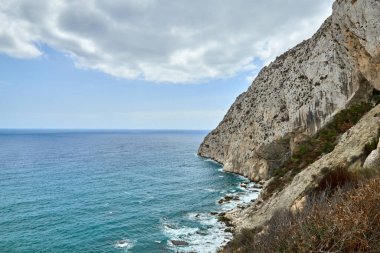 Dramatik Kıyı Kayalıkları Kristal berrak Su Dalgaları Sahil Kıyısı Güneşli Akdeniz Günü 'nün sunduğu Idyllic Seaside Retreat