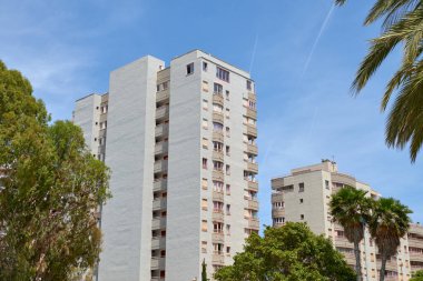 Göz kamaştırıcı İspanyol Sahil Uçurumu: Yüksek Binalar ve Parlak Yaz Gökyüzü Altında Sallanan Palmiyeler
