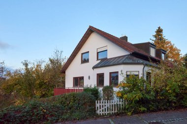 Göz kamaştırıcı derecede güzel bir ev canlı ve renkli yaprakların arasına yerleştirilmiş, resimli bir sonbahar günü sergileniyor.