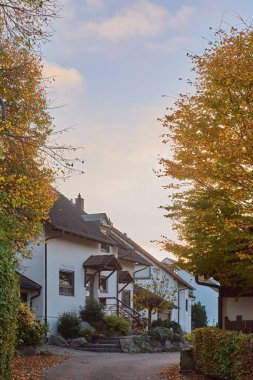 Göz kamaştırıcı derecede güzel bir ev canlı ve renkli yaprakların arasına yerleştirilmiş, resimli bir sonbahar günü sergileniyor.