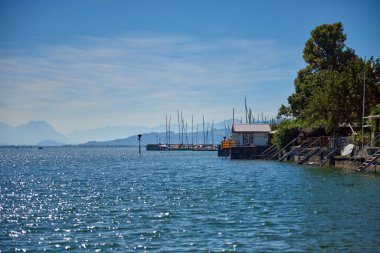 Germany, Lindau island city houses at bodensee lake water panorama view to austrian mountains, alps, pfaender peak and nature landscape. clipart