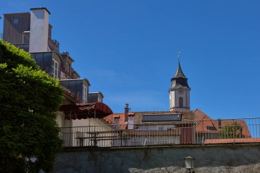 This captivating image showcases the architectural splendor of medieval Europe, featuring a panoramic view of Lindau, Germany. The foreground is dominated by a majestic town hall, its Gothic and clipart