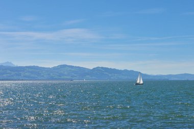 Bodensee 'nin nefes kesici Panorama' sı. Beyaz yelkenliler ve Lindau, Almanya 'dan İsviçre Alpleri. Idyllic Yaz Sahnesi Avrupa Tatil Cenneti Şovu Yelkencilik, Doğa ve Dağ Vistalarını Yakalıyor