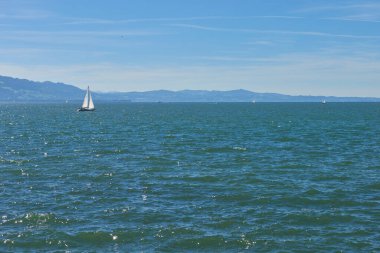 Bodensee 'nin nefes kesici Panorama' sı. Beyaz yelkenliler ve Lindau, Almanya 'dan İsviçre Alpleri. Idyllic Yaz Sahnesi Avrupa Tatil Cenneti Şovu Yelkencilik, Doğa ve Dağ Vistalarını Yakalıyor