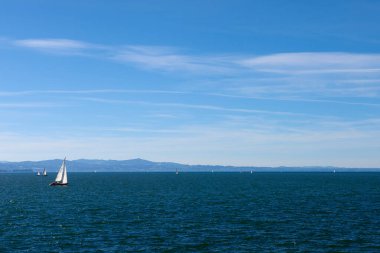 Bodensee 'nin nefes kesici Panorama' sı. Beyaz yelkenliler ve Lindau, Almanya 'dan İsviçre Alpleri. Idyllic Yaz Sahnesi Avrupa Tatil Cenneti Şovu Yelkencilik, Doğa ve Dağ Vistalarını Yakalıyor