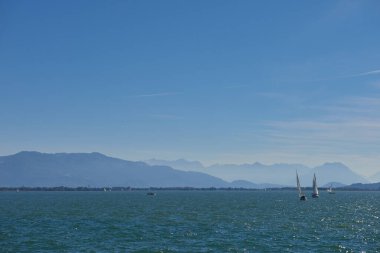 Bodensee 'nin nefes kesici Panorama' sı. Beyaz yelkenliler ve Lindau, Almanya 'dan İsviçre Alpleri. Idyllic Yaz Sahnesi Avrupa Tatil Cenneti Şovu Yelkencilik, Doğa ve Dağ Vistalarını Yakalıyor