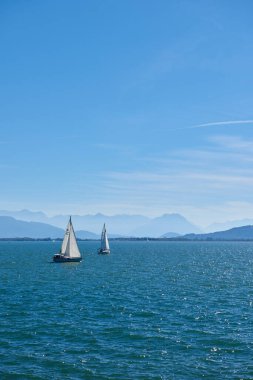 Bodensee 'nin nefes kesici Panorama' sı. Beyaz yelkenliler ve Lindau, Almanya 'dan İsviçre Alpleri. Idyllic Yaz Sahnesi Avrupa Tatil Cenneti Şovu Yelkencilik, Doğa ve Dağ Vistalarını Yakalıyor