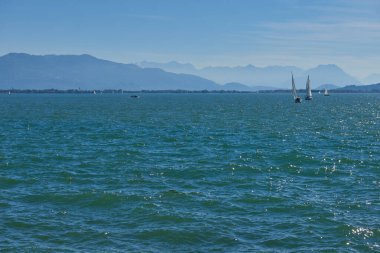 Bodensee 'nin nefes kesici Panorama' sı. Beyaz yelkenliler ve Lindau, Almanya 'dan İsviçre Alpleri. Idyllic Yaz Sahnesi Avrupa Tatil Cenneti Şovu Yelkencilik, Doğa ve Dağ Vistalarını Yakalıyor